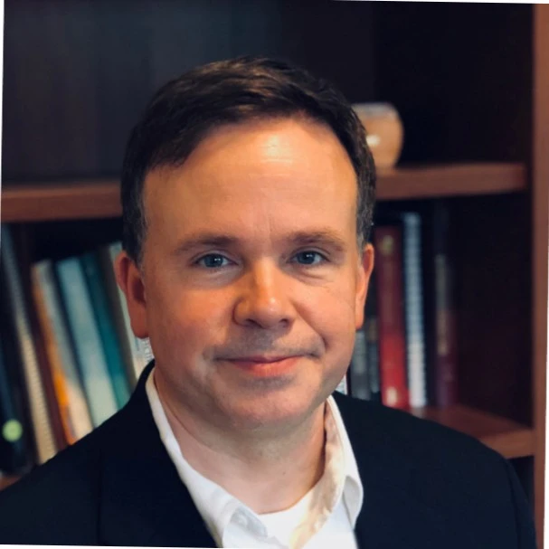 Businessman in office setting with bookshelves, testimonial photo