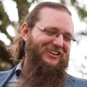 Bearded man smiling outdoors, client testimonial photo