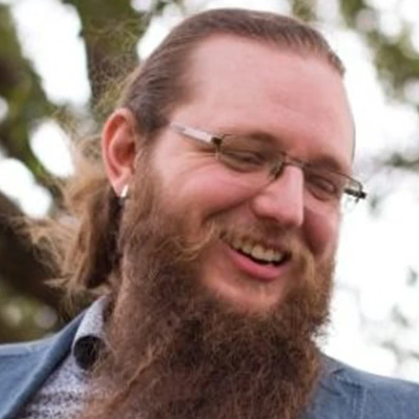 Bearded man smiling outdoors, client testimonial photo