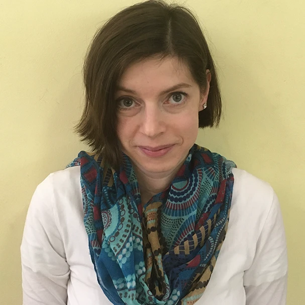 Woman in sleeveless top smiling indoors, testimonial headshot