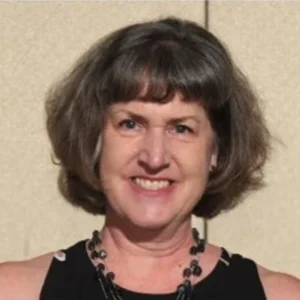 Woman with straight hair and scarf smiling at the camera, testimonial photo