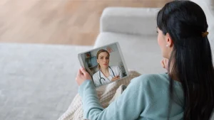 Patient using a tablet to video chat with a doctor, representing virtual care in healthcare explainer video.